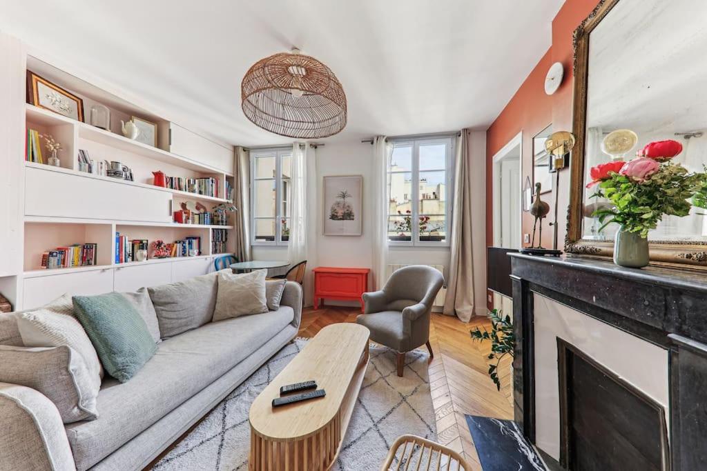un salon avec un canapé et une cheminée dans l'établissement Appartement cosy au cœur du Marais, à Paris