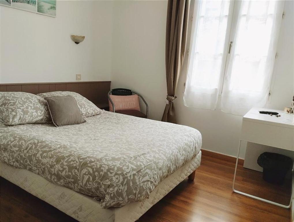 une chambre avec un lit, un bureau et une fenêtre dans l'établissement Appartement Lyon, à Lyon