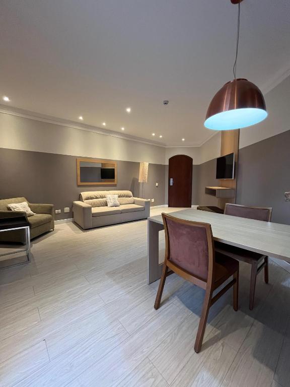 a living room with a table and a couch at Flat no Gonzaga - Santos in Santos