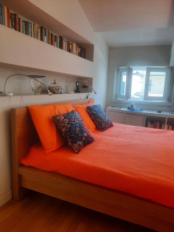 a bedroom with a bed with orange sheets and pillows at Viareggio Mare blu in Viareggio