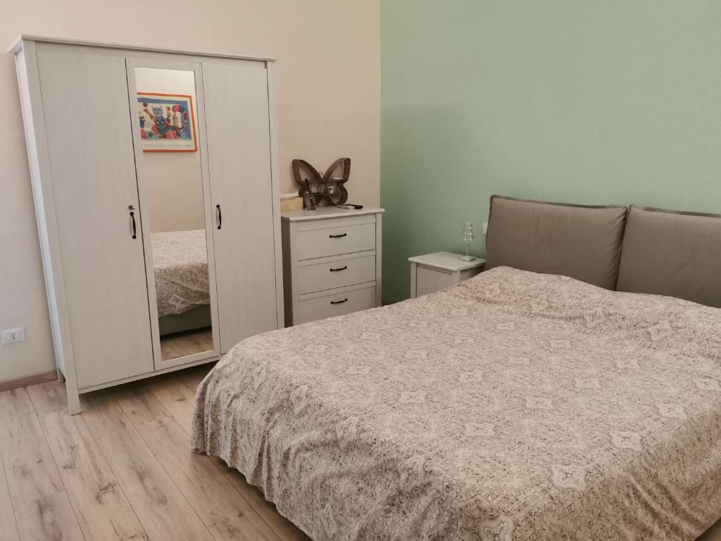 a bedroom with a bed and a dresser with a mirror at Kikka's House in La Spezia