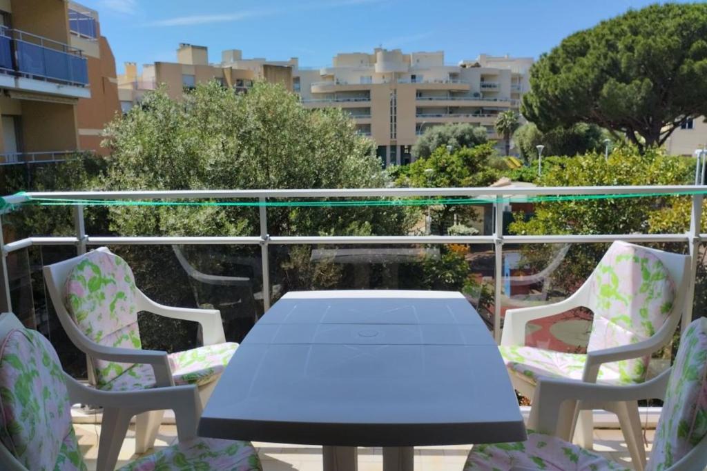 une table blanche et des chaises sur un balcon dans l'établissement Pleasant studio near the sea, à Cavalaire-sur-Mer