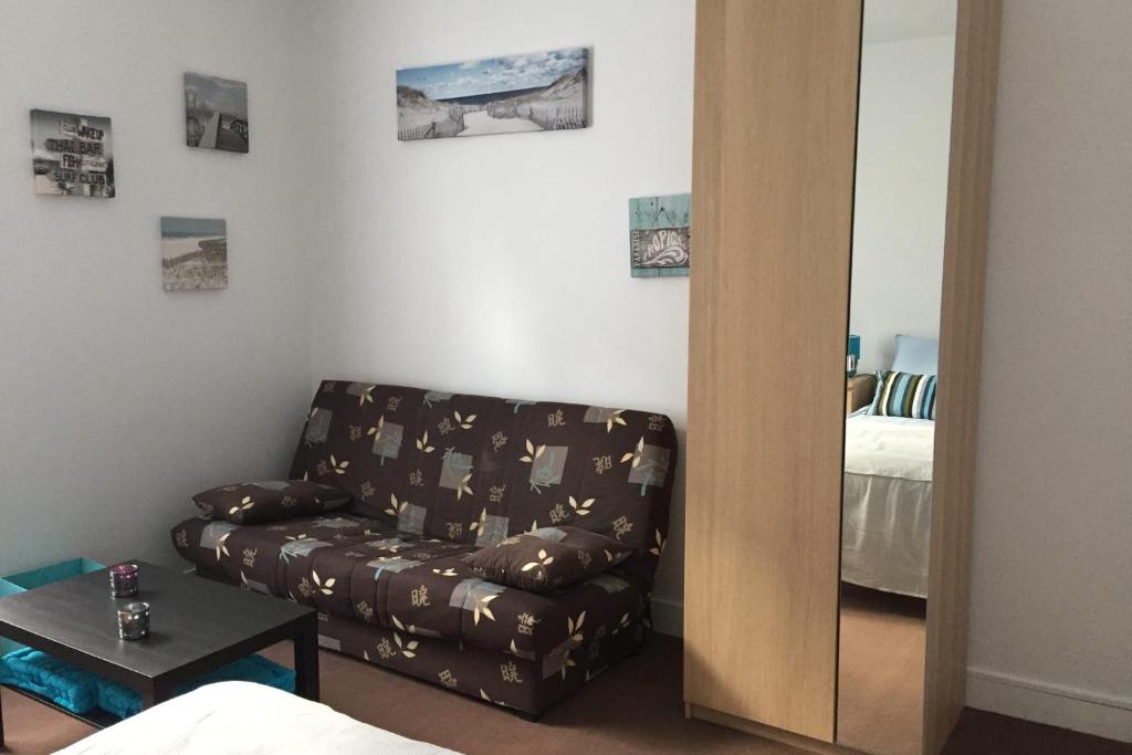 un salon avec un canapé et un miroir dans l'établissement Large studio in the heart of Nantes, à Nantes