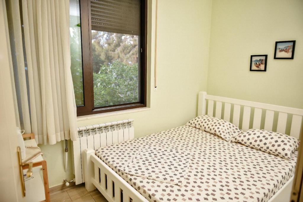una piccola camera da letto con un letto e una finestra di Panoramic View over Shkodra's Lake - Serena Home a Shkodër