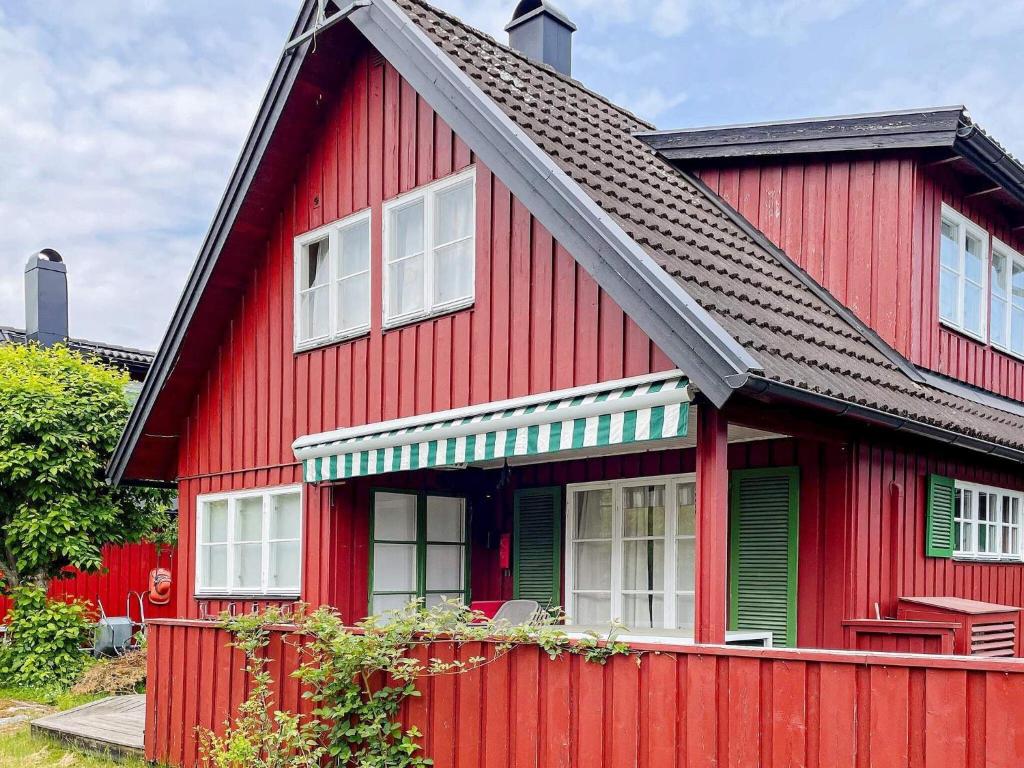 a red house with a black roof at 4 star holiday home in GRISSLEHAMN-By Traum in Grisslehamn