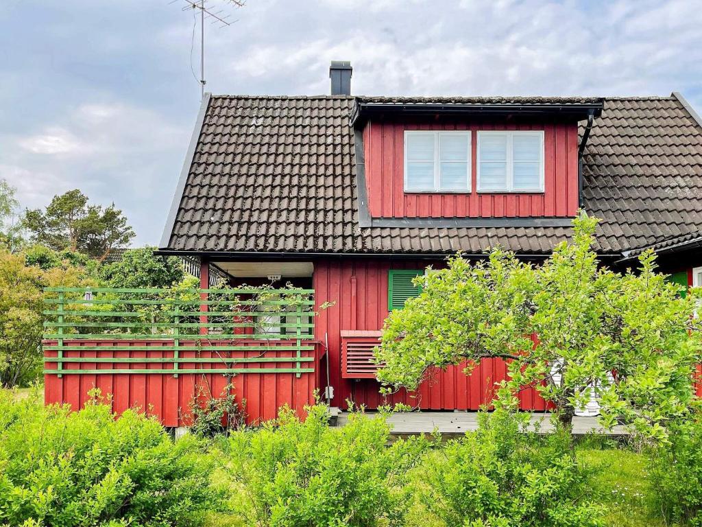 a red house with a red fence in front of it at 4 star holiday home in GRISSLEHAMN-By Traum in Grisslehamn