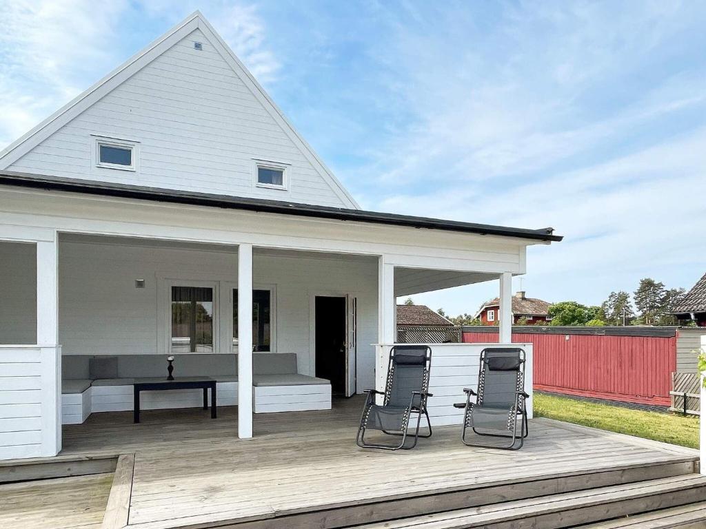 een wit huis met twee stoelen en een bank op een terras bij 4 star holiday home in KÖPINGSVIK-By Traum in Köpingsvik