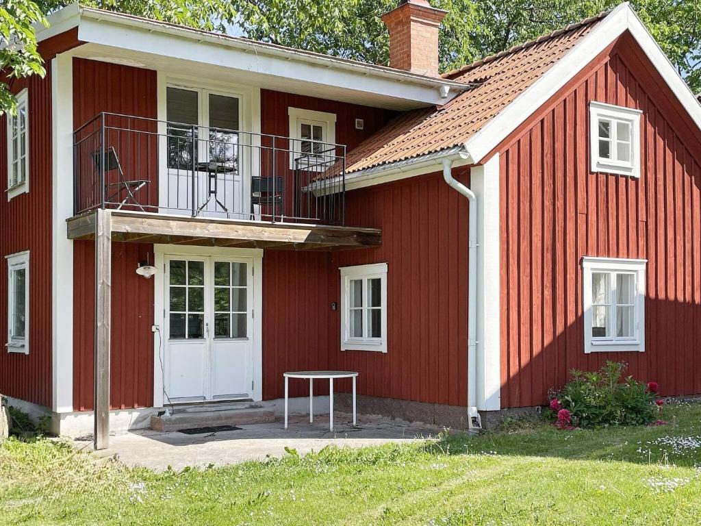a red house with a bench in front of it at 6 person holiday home in Ödeshög in Ödeshög