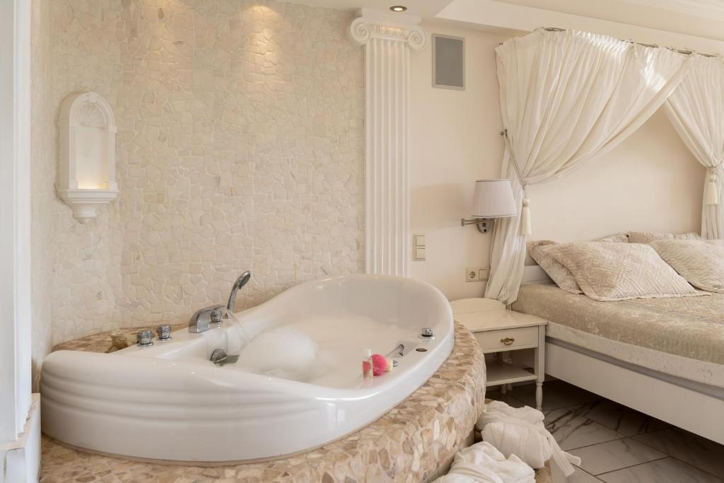 a white bath tub in a bedroom with a bed at #1 Luxury Jacuzzi Penthouse In Quiet Centre Riga in Rīga