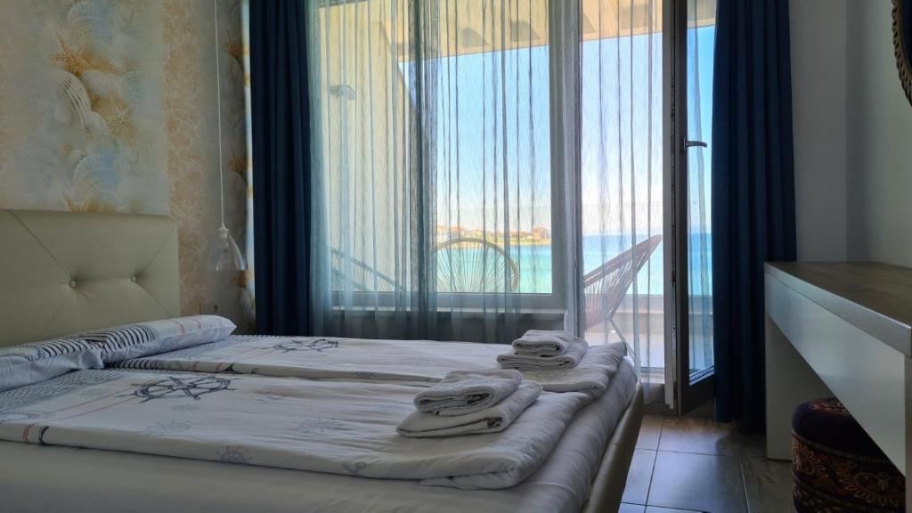 a hotel room with a bed with towels on it at Villa Flora in Sozopol