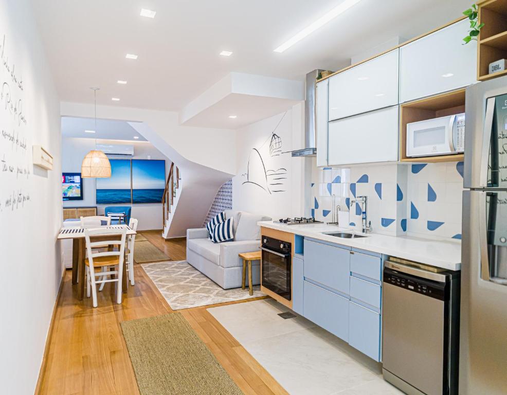 Hotel Cobertura no Coraçao de Ipanema, a kitchen with blue cabinets and a dining room at Cobertura no Coraçao de Ipanema in Rio de Janeiro