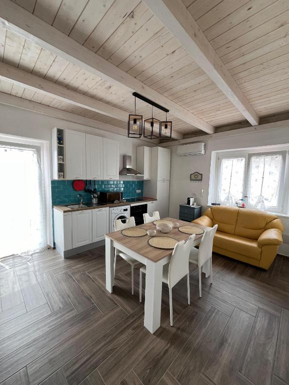 cocina y comedor con mesa y sofá en Casa vacanze Iris, en Carbonia