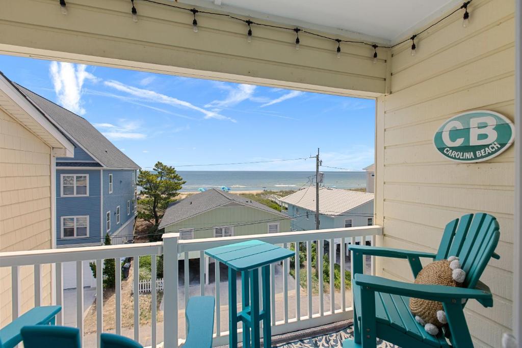 a patio with two chairs and a table on a balcony at Tropical Winds - Ferda Buoys in Carolina Beach