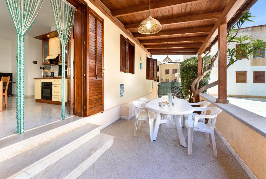un patio con tavolo e sedie bianchi di Casa Karuscia a San Vito lo Capo