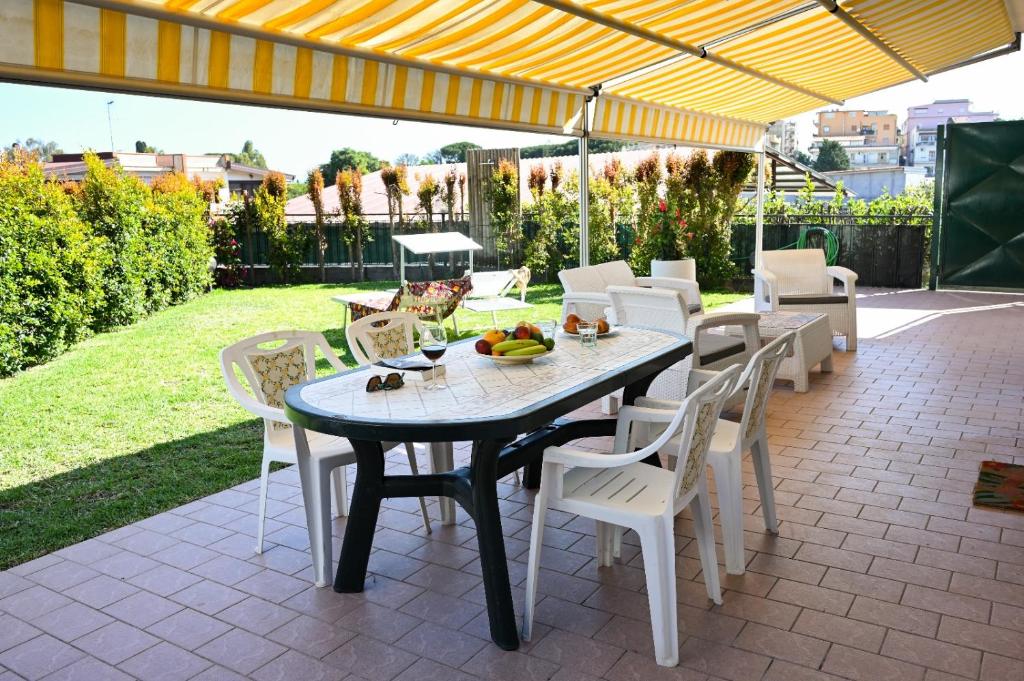 una mesa de comedor y sillas en un patio con sombrilla en Il Giardino di Morris, en Giardini Naxos