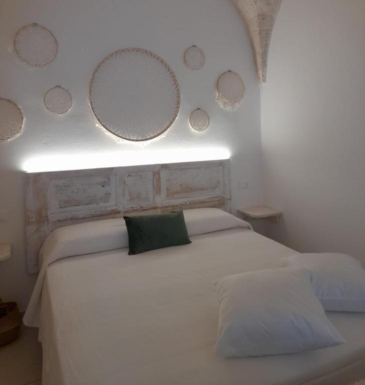 a bedroom with a white bed with mirrors on the wall at Casamareluna in Ostuni