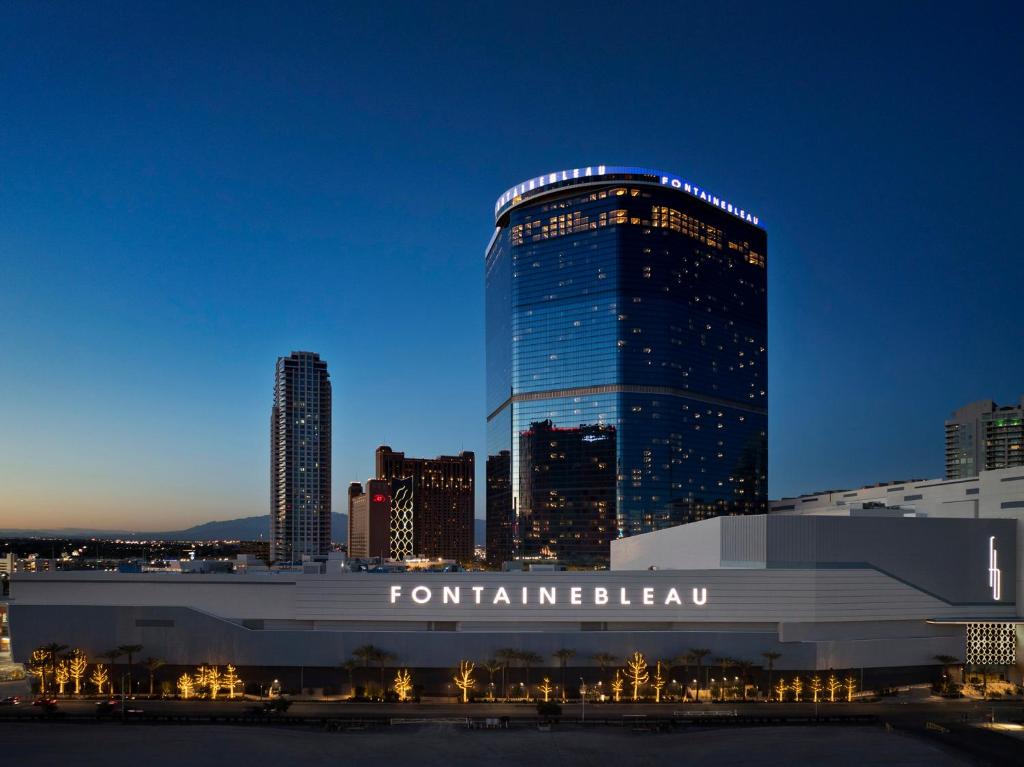 een hoog gebouw voor een stad 's nachts bij Fontainebleau Las Vegas in Las Vegas