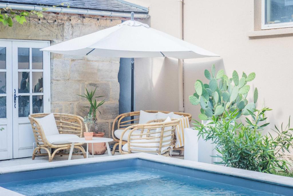 ブリーヴ・ラ・ガイヤルドにあるMaison Victoireのパティオ(パラソル、椅子付)、プールが備わります。