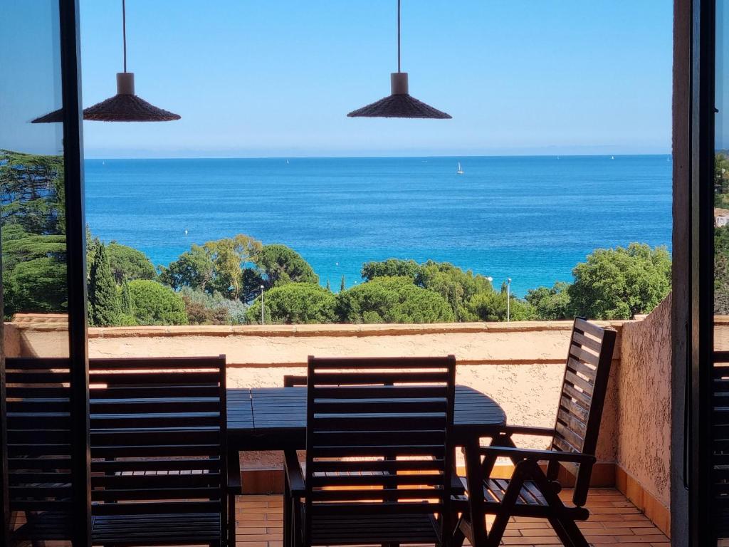 - deux chaises et une table avec vue sur l'océan dans l'établissement Le Grand Bleu - T4 avec garage - Wifi - Vue mer, au Lavandou