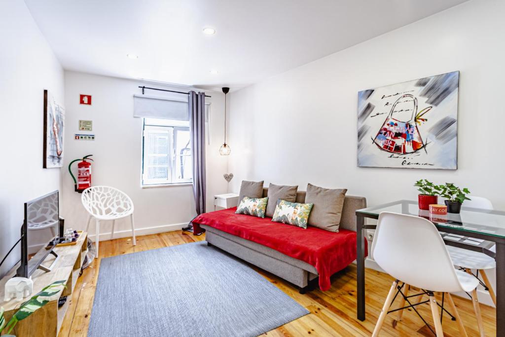 un soggiorno con un divano rosso e un tavolo di Visit Lisbon4fun - Alfama a Lisbona