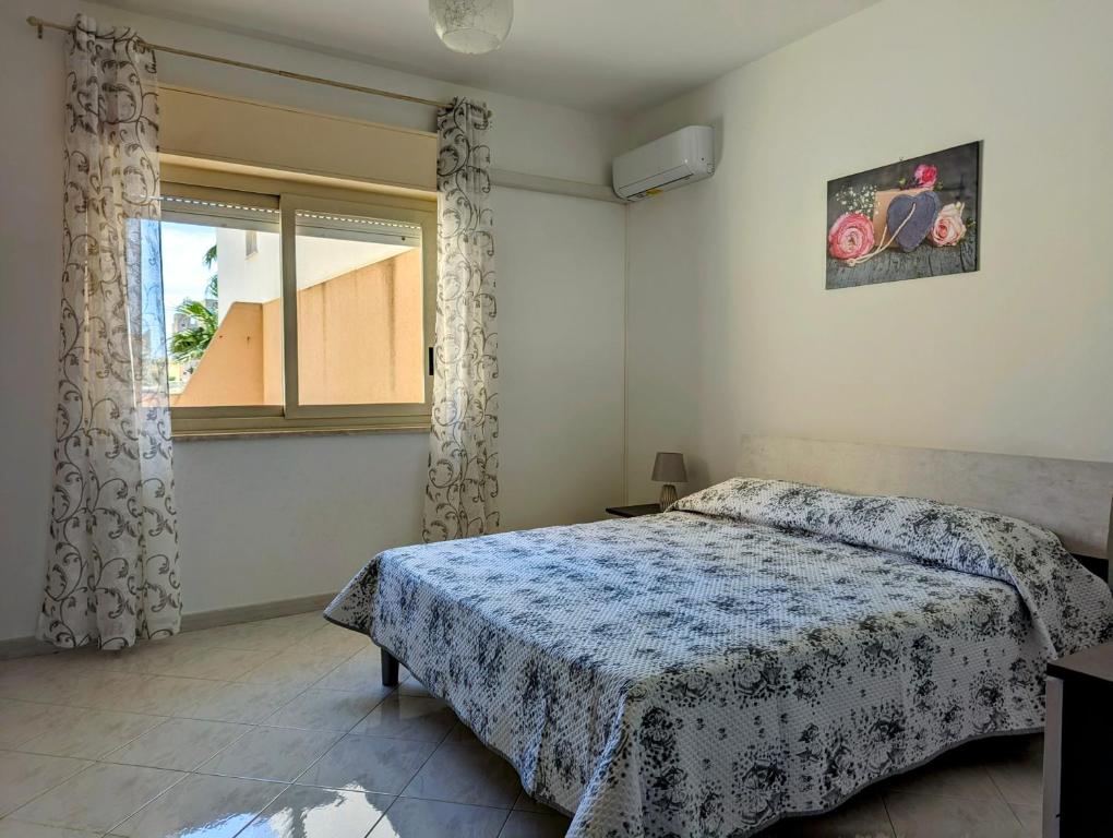 una camera da letto con un letto e una finestra di La Terrazza di Trapani, a due passi dal mare a Trapani