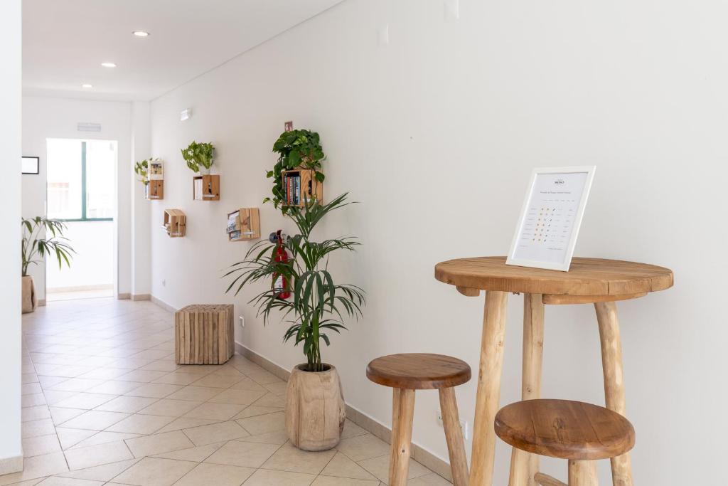 a room with two wooden stools and a plant at Estudios Salinas - Fuseta in Fuzeta