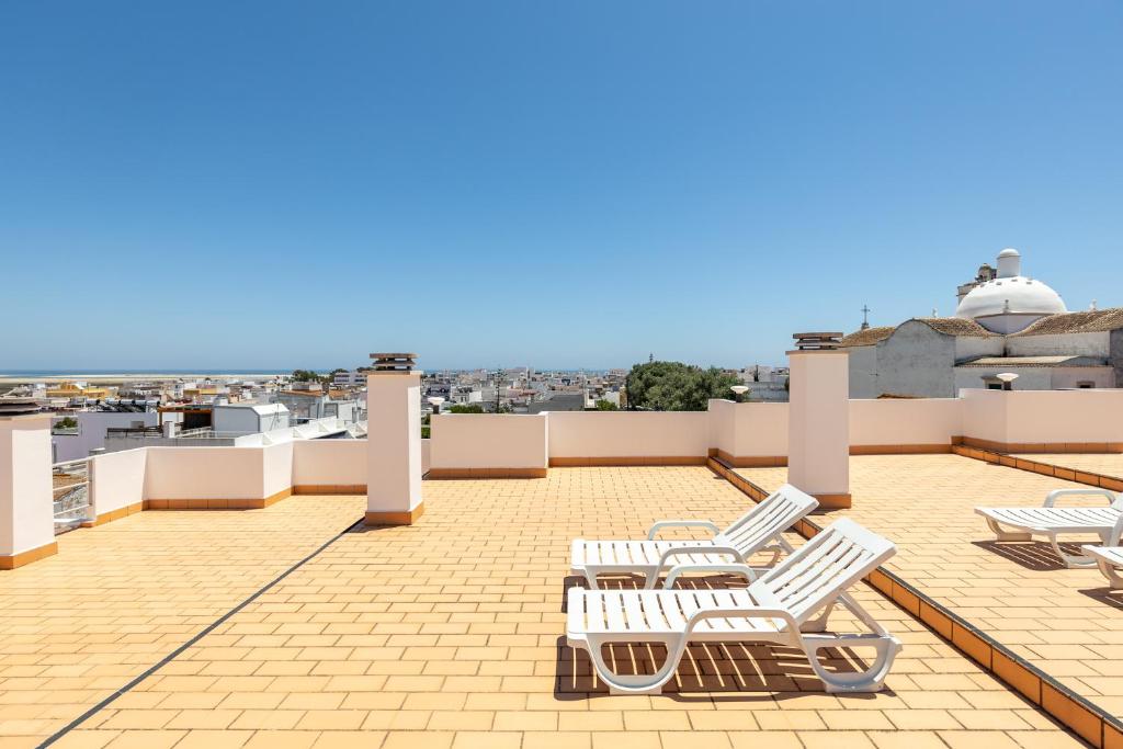 a group of white chairs sitting on a roof at Estudios Salinas - Fuseta in Fuzeta