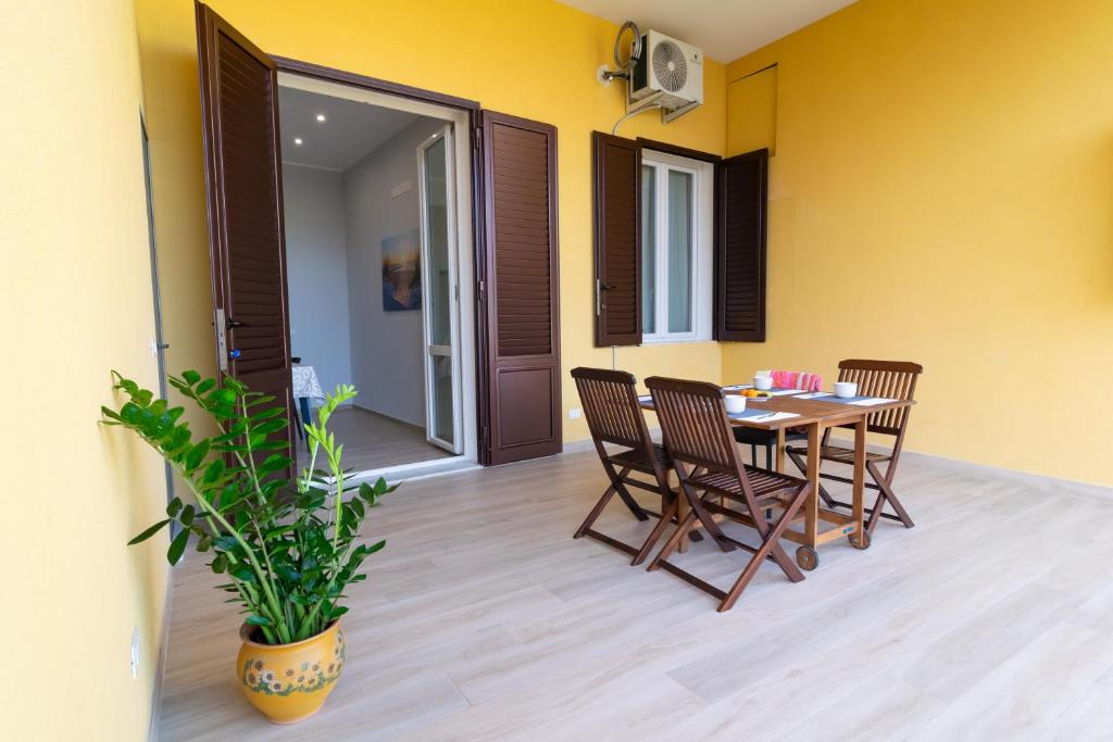 a patio with a table and chairs and a plant at Veranda sul Verde in Ficarazzi