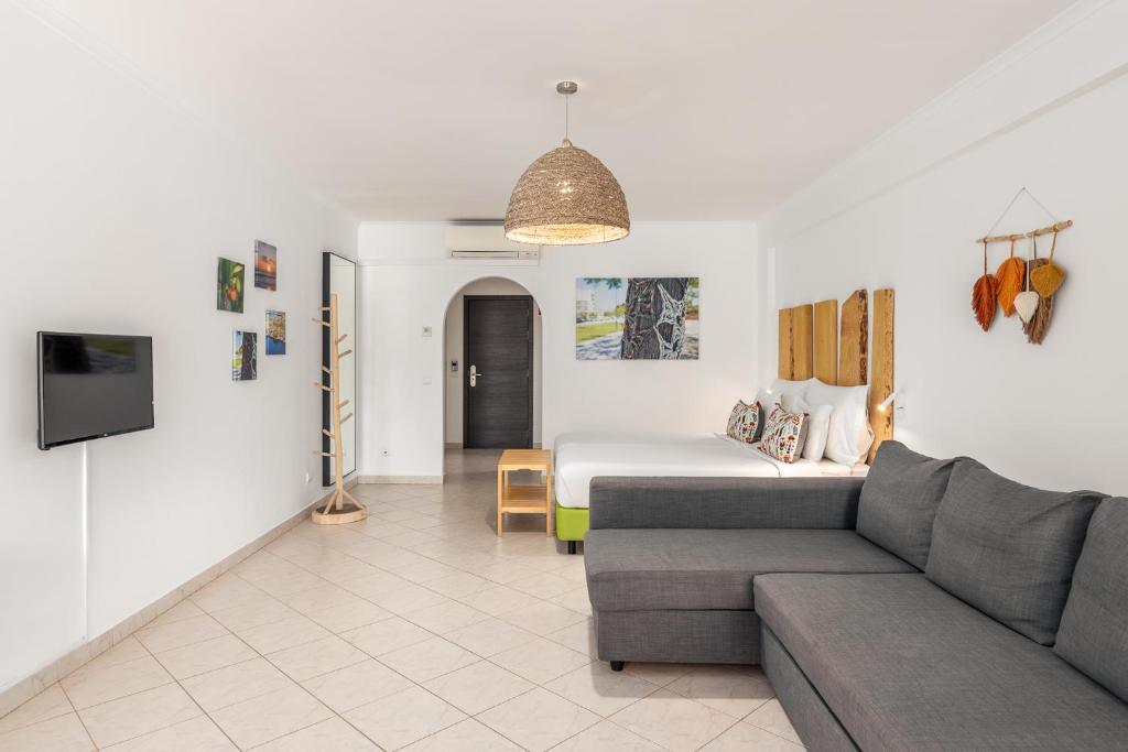 a living room with a couch and a bed at Estudios Salinas - Fuseta in Fuzeta