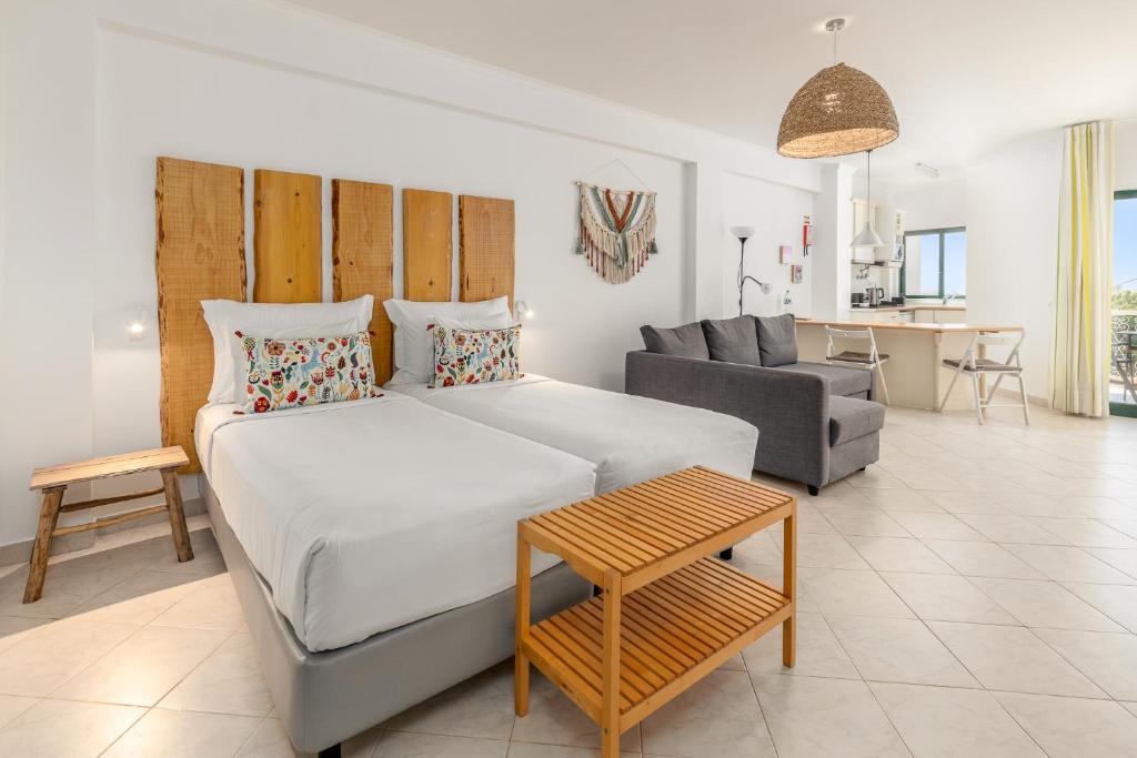 a bedroom with a large white bed and a couch at Estudios Salinas - Fuseta in Fuzeta