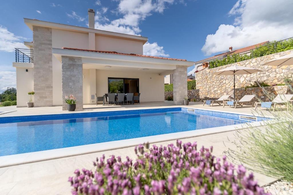 a villa with a swimming pool and a house at Villa Mihojka in Malinska