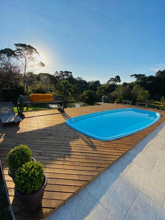 a blue swimming pool on a wooden deck at Chácara de lazer Mandirituba in Rio da Várzea