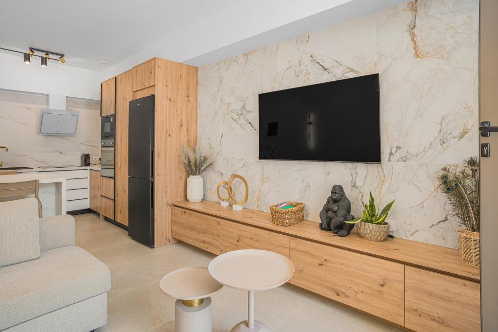 a living room with a television on a wall at Infinity luxury suite in Malia