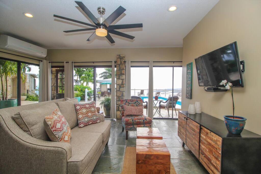 a living room with a couch and a flat screen tv at Executive 1 Bedroom Poolside Apt Kilele suite in Christiansted