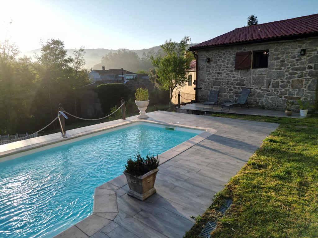 a swimming pool in the backyard of a house at Cozy Galician Stone Farmhouse with Pool in Santo Tomé