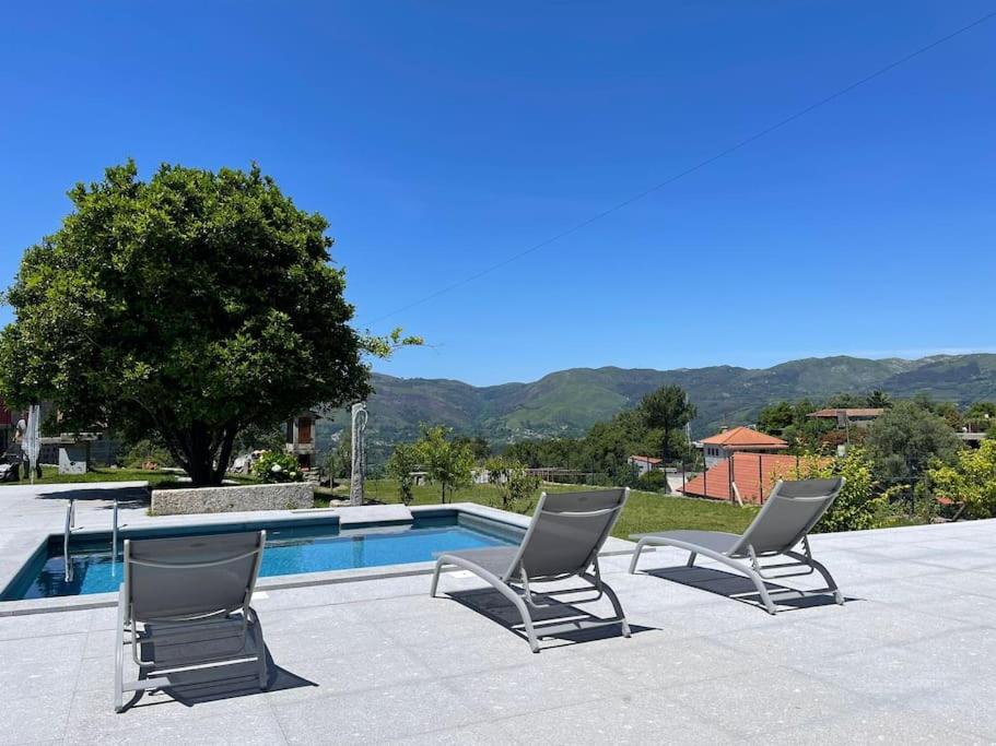 un paio di sedie e una piscina di Casa Curto a Terras de Bouro