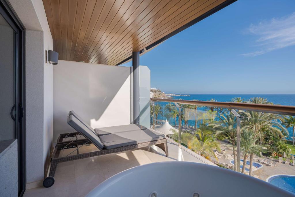 a bathroom with a tub and a view of the ocean at Radisson Blu Resort Gran Canaria in La Playa de Arguineguín