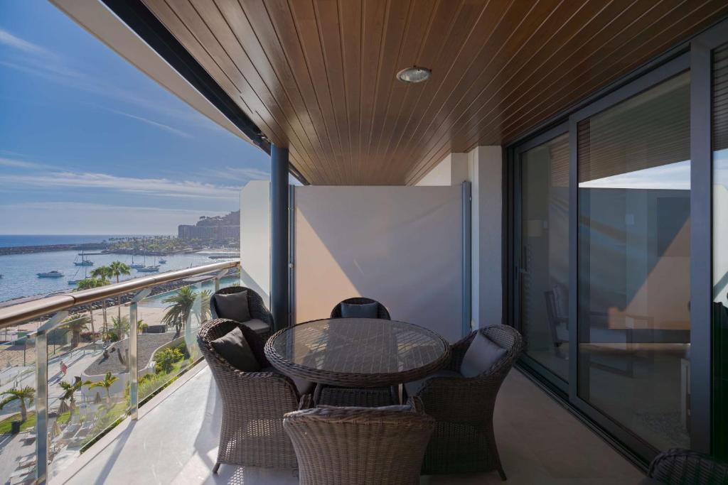 a balcony with a table and chairs and the ocean at Radisson Blu Resort Gran Canaria in La Playa de Arguineguín
