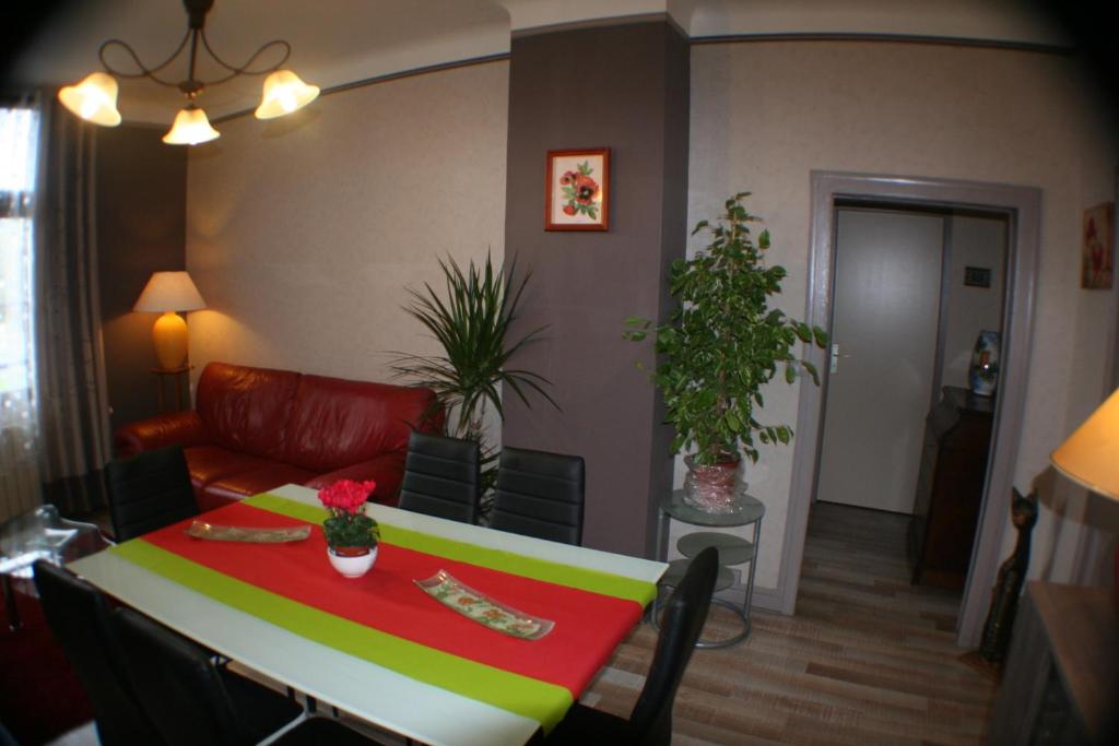 uma sala de estar com uma mesa e um sofá em Appartement Les Berges de l'Ornain em Bar-le-Duc