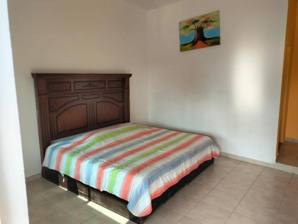 a bedroom with a bed with a wooden headboard at Villas Yoleth Hotel in Chachalacas