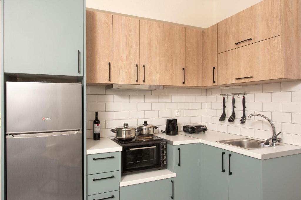 a kitchen with wooden cabinets and a stainless steel refrigerator at Agnantio in Agios Nikitas