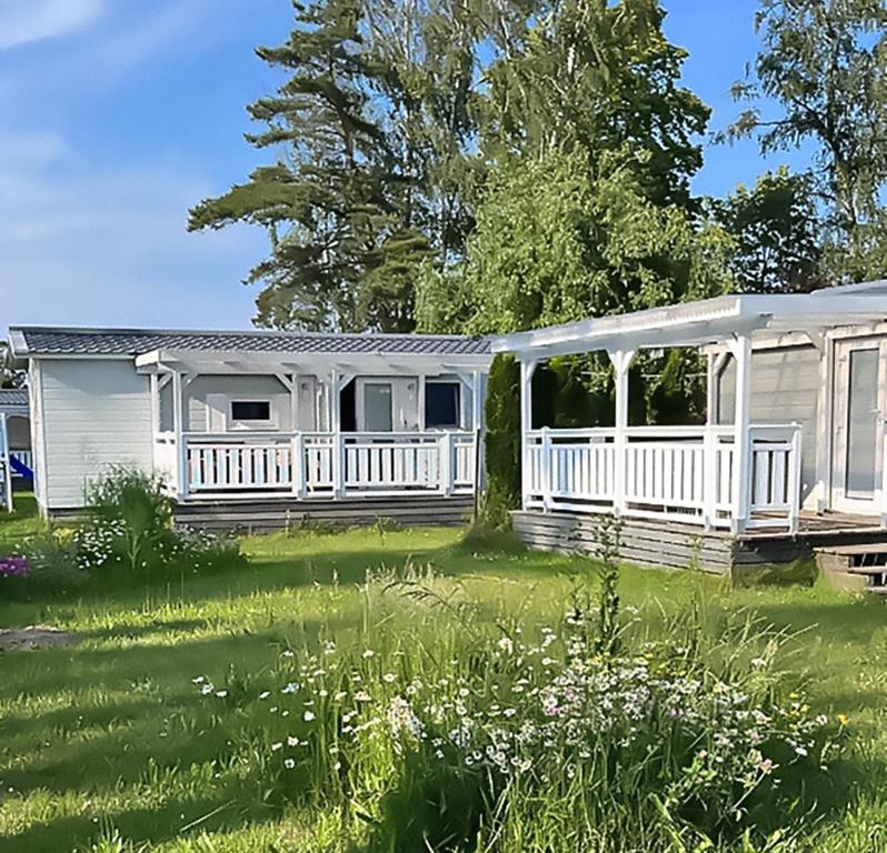 ein Haus mit einem weißen Zaun und einem Hof in der Unterkunft Delta Mare - Ferienhaus Folklore - 250m zum Strand in Dziwnów