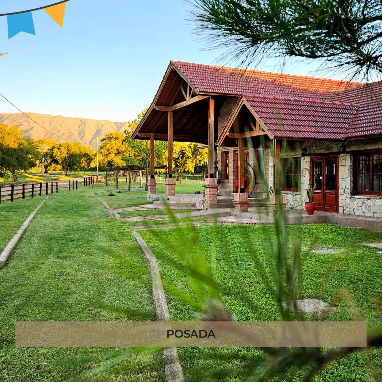 a building with a red roof in a field at Ayres del Golf Posada-Restó in Merlo