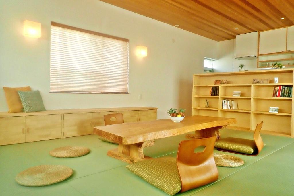 石垣島的住宿－Guest House Ishigaki，客厅配有木桌和椅子
