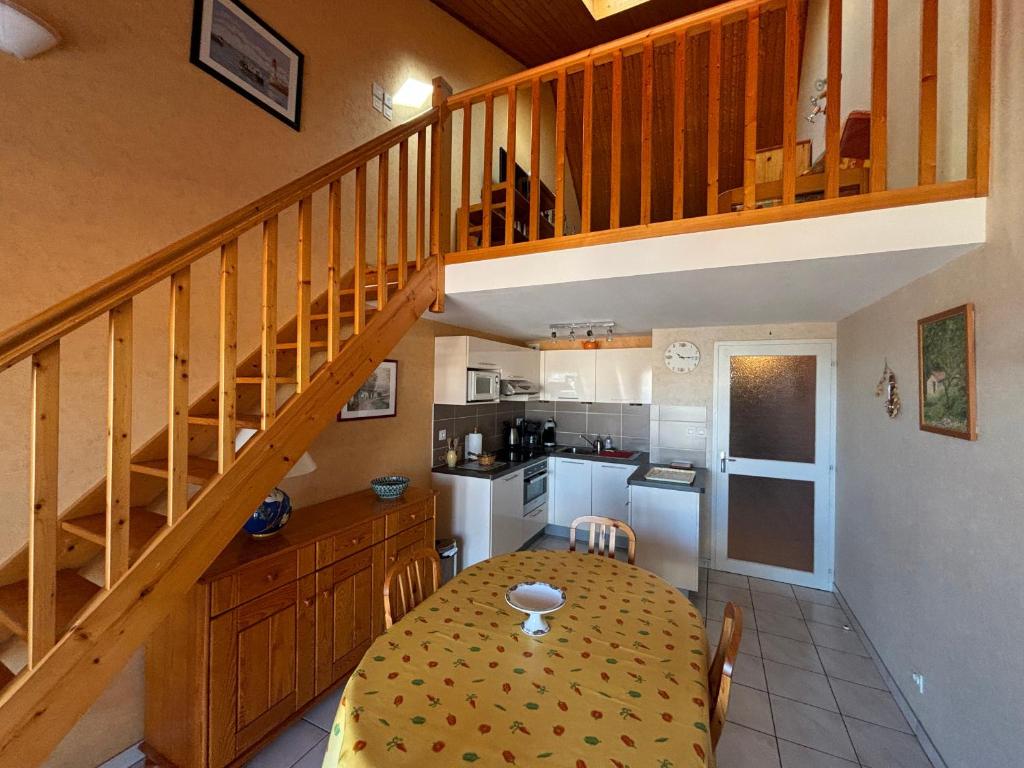 une cuisine et une salle à manger avec une table et un escalier dans l'établissement Appartement T3 - à 50m de la plage, 2 chambres, garage - FR-1-197-225, à Les Sables-dʼOlonne