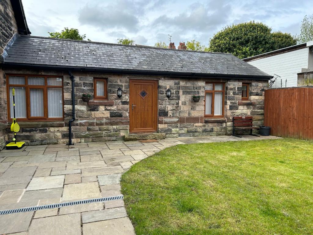 a small stone house with a yard in front of it at The Coachmans Cottage in Rock Ferry