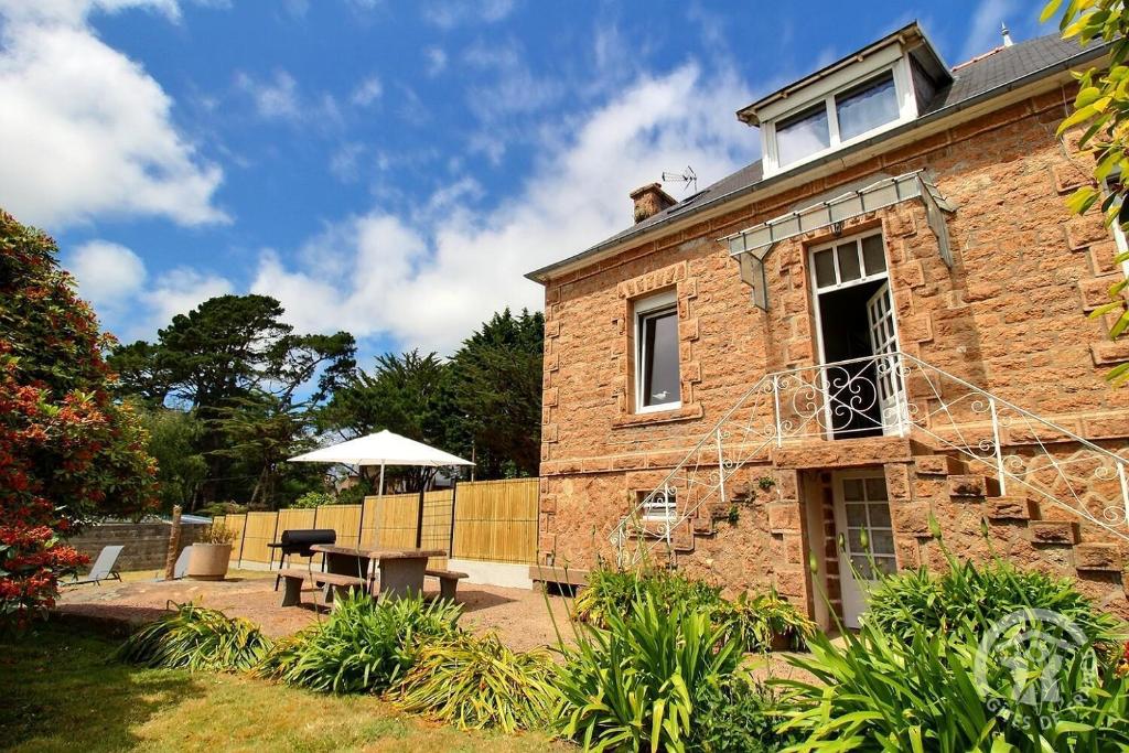 une maison en briques avec une table et un banc dans l'établissement Roz vallee 1, à Perros-Guirec