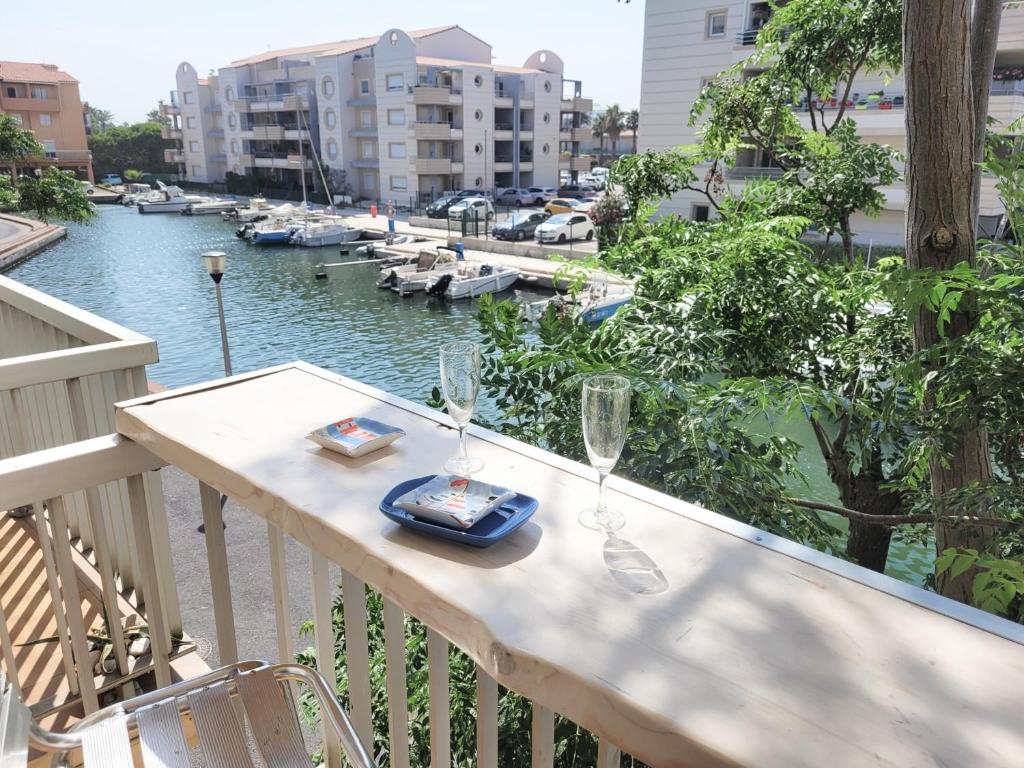 - un balcon avec une table et des verres à vin dans l'établissement Joli T2 rénové - 4 Pers - Parking - Wifi - Proche Mer - FR-1-794-101, à Canet