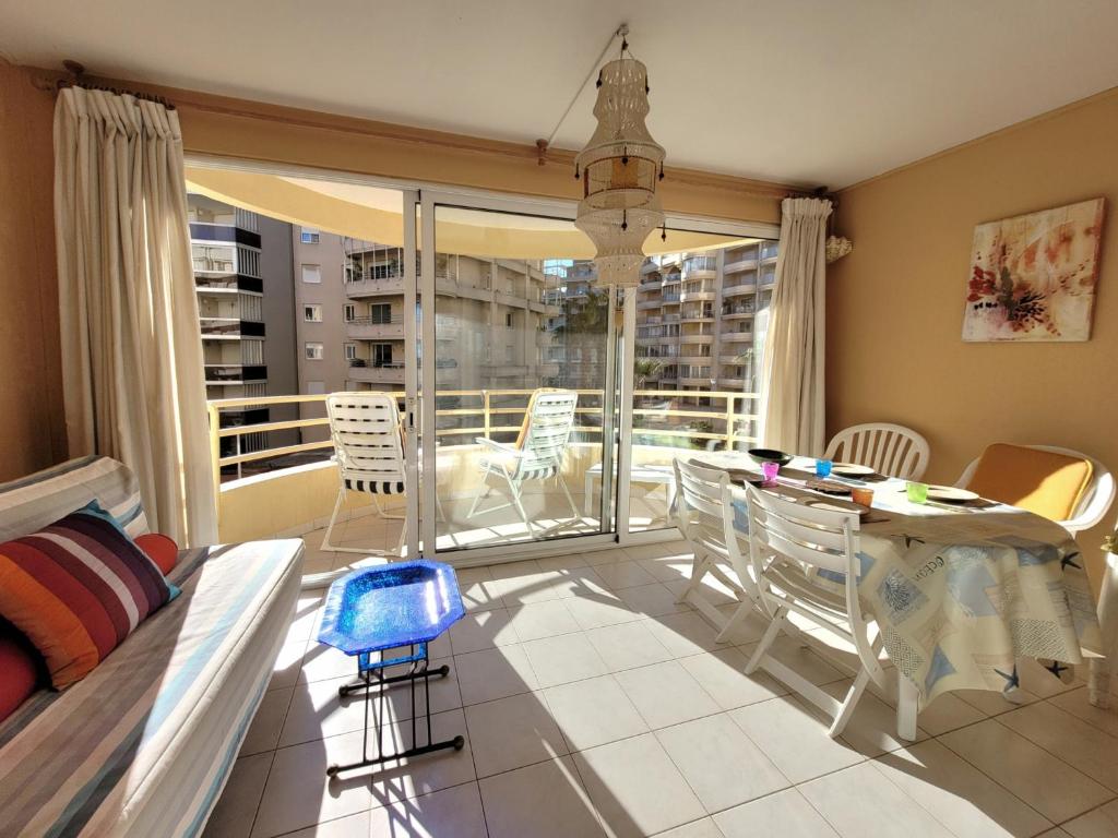 un salon avec une table et des chaises et un balcon dans l'établissement Beau T3 traversant - Front de mer - 100m Plage - Parking privé - 2ème étage - FR-1-794-112, à Canet