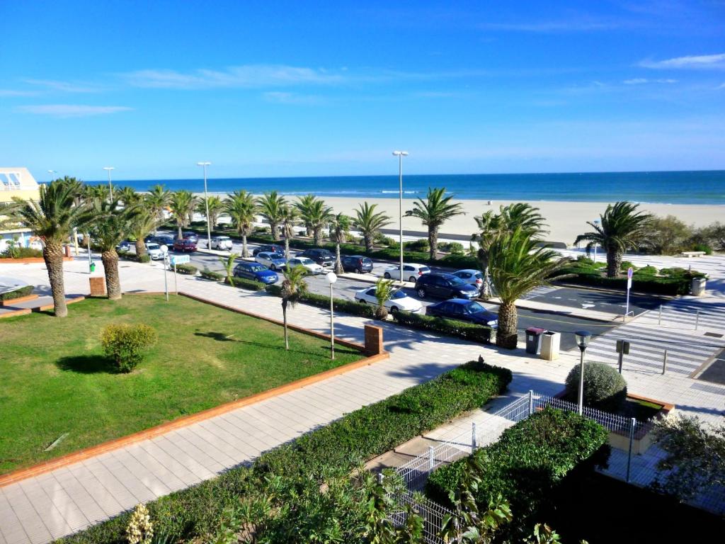 - une vue sur un parking avec des palmiers et la plage dans l'établissement Canet-en-Roussillon - T2 moderne - Accès plage - Parking privé - FR-1-794-120, à Canet